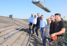 Freuen sich über den Baubeginn auf dem Dach des technischen Rathauses: Stefan Elias, Leiter des Amtes für Gebäudemanagement, Marcel Kürten, Sachgebietsleiter TGA (Technische Gebäudeausrüstung), Beigeordneter Martin Gentzsch, Peter Podgorny, Geschäftsführer der Planungsfirma ITS, Bernd Füllgräbe, Projektleiter der ausführenden Elektro-Firma des-tec sowie die Dachdecker von der Firma YOS. Foto: Stadt Ratingen