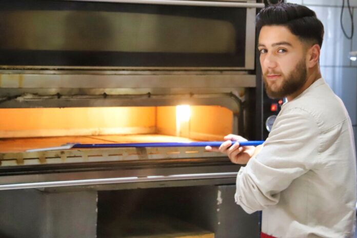 Berkan Kale ist der Inhaberin der Pizzeria: Er steht selbst am Ofen - und ist überzeugt von seinen Pizzen. Foto: Volkmann