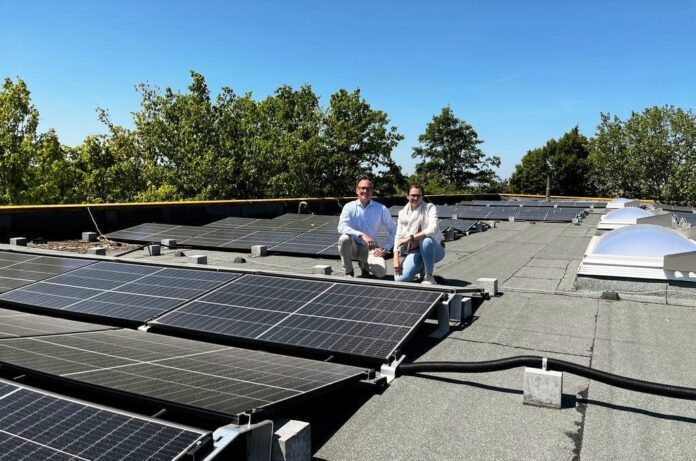 Dina Sulewski, Öffentlichkeitsarbeit der Stadtwerke Wülfrath, und Jens Schütt, Geschäftsführer Tischlerei Knoche, an der neuen Solaranlage. Foto: Stadtwerke Wülfrath