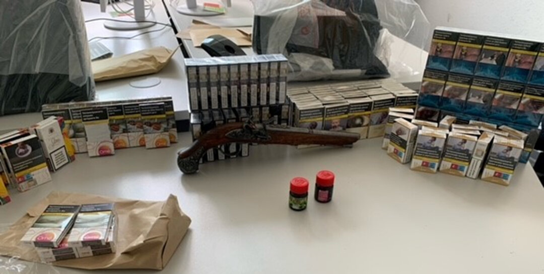Es wurden mehrere Schachteln unversteuerten Tabaks sowie eine alte Schusswaffe sichergestellt. Foto: Polizei