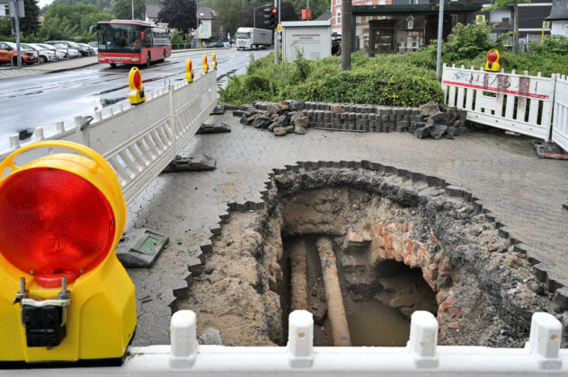 Ein gewaltiges Loch klafft in der Zufahrt des Busbahnhofs Neviges. Bei der Suche nach der Ursache einer Fahbahnsenkung ist hier ein historischer Kanal entdeckt worden. Foto: Mathias Kehren