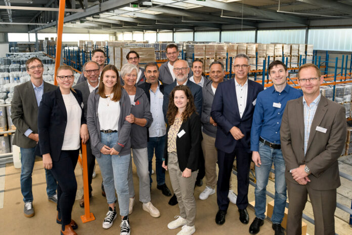 Familie Dörrenhaus und Teilnehmer des Wirtschaftsfrühstücks beim Gruppenbild in einem Lager der Velberter Spedition. Foto: Schlüsselregion / Mathias Kehren