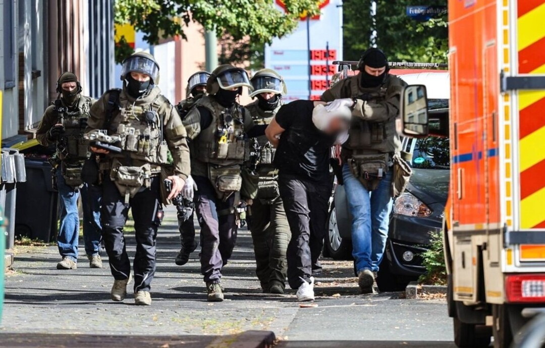 Spezialkräfte der Polizei führen einen Verdächtigen ab.