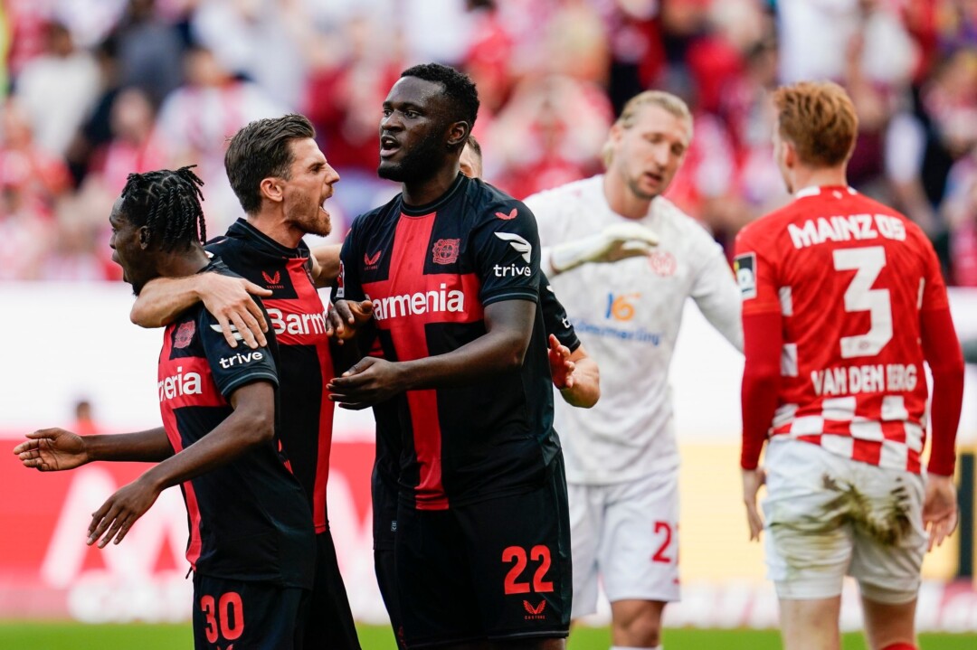 Leverkusens Mannschaft jubelt über das Eigentor von Sepp van den Berg (r) von Mainz zum 0:1.
