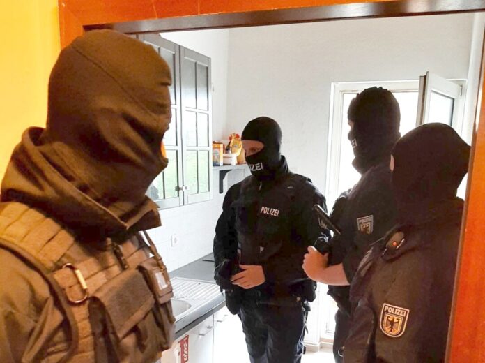 Einsatzkräfte bei der Durchsuchung. Foto: Polizei