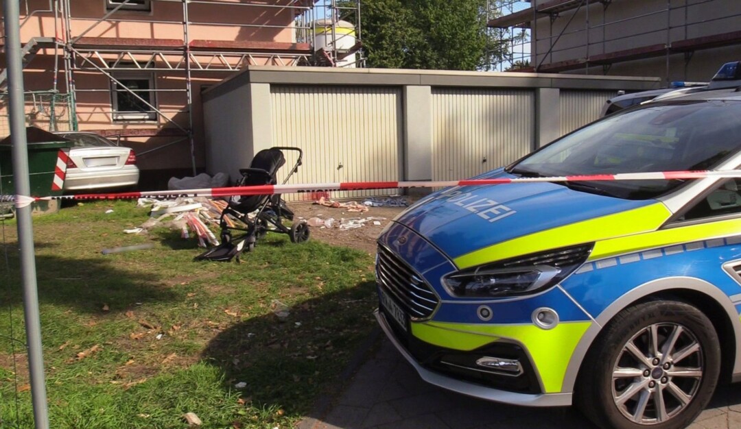 Ein Auto (links hinten) steht an einem Haus, nachdem der Fahrer zuvor eine Frau und ein Kind angefahren hatte.