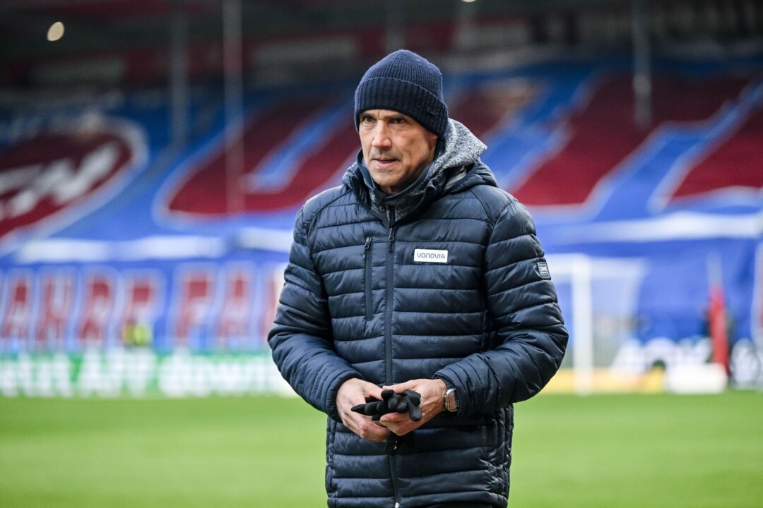 Mann in Winterkleidung auf Fußballfeld