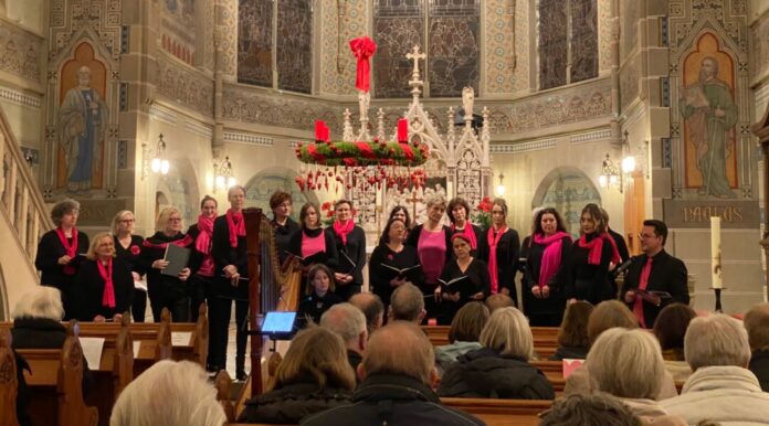 Chor singt in festlich geschmückter Kirche.