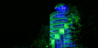 Beleuchteter Turm bei Nacht mit grüner Beleuchtung