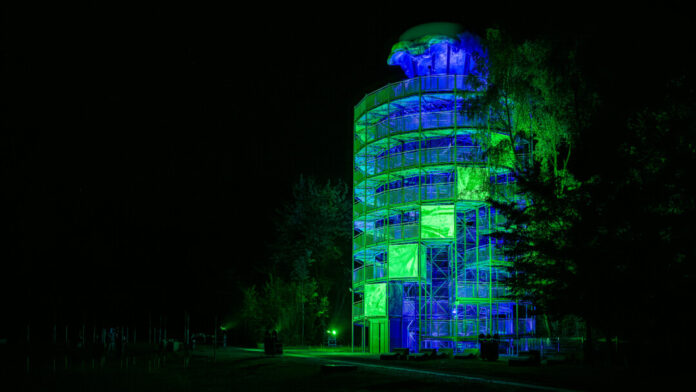 Beleuchteter Turm bei Nacht mit grüner Beleuchtung