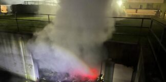 Feuerwehreinsatz bei Nacht mit Rauch und Lichtern.