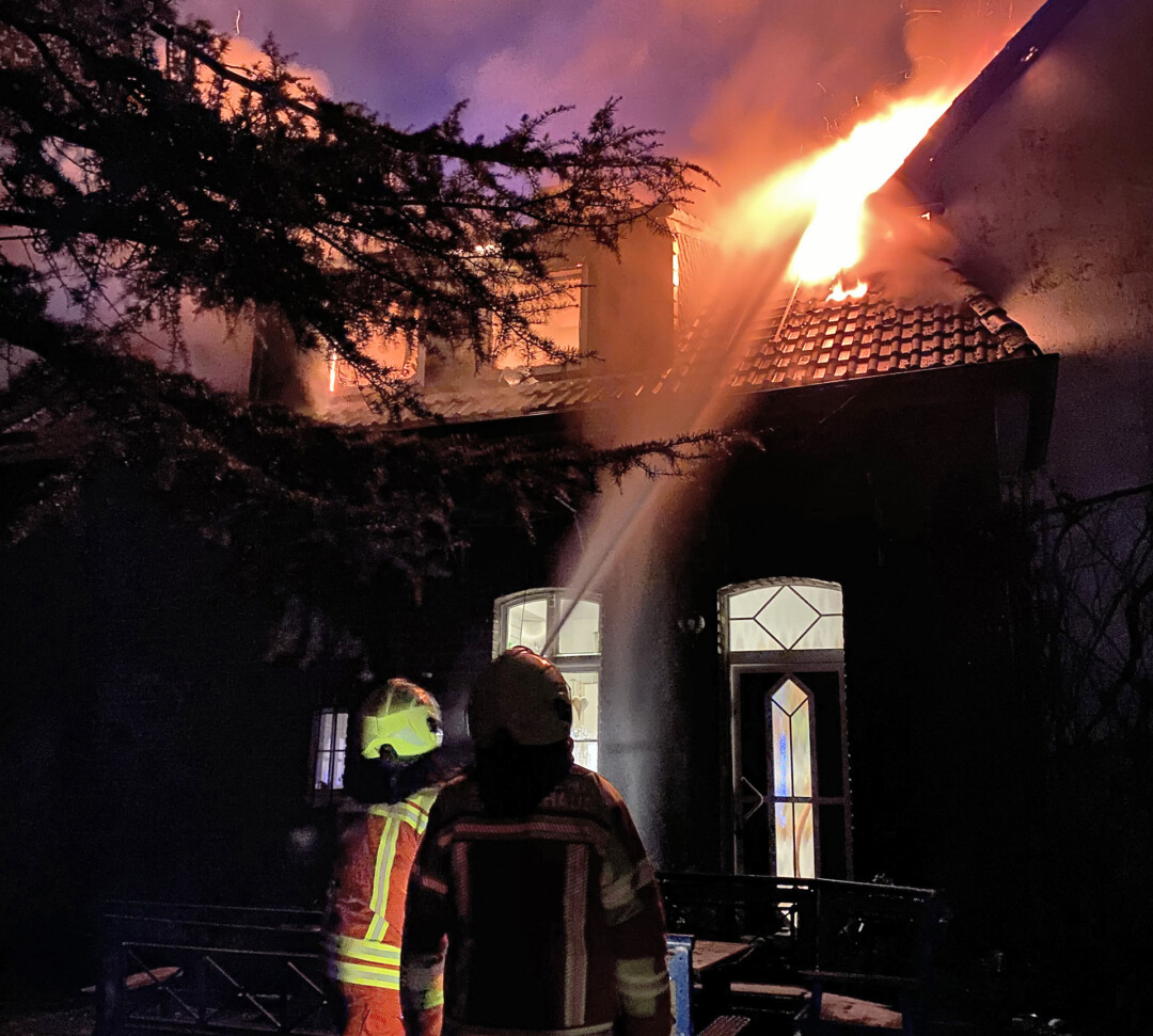 Feuerwehr löscht Hausbrand bei Nacht.