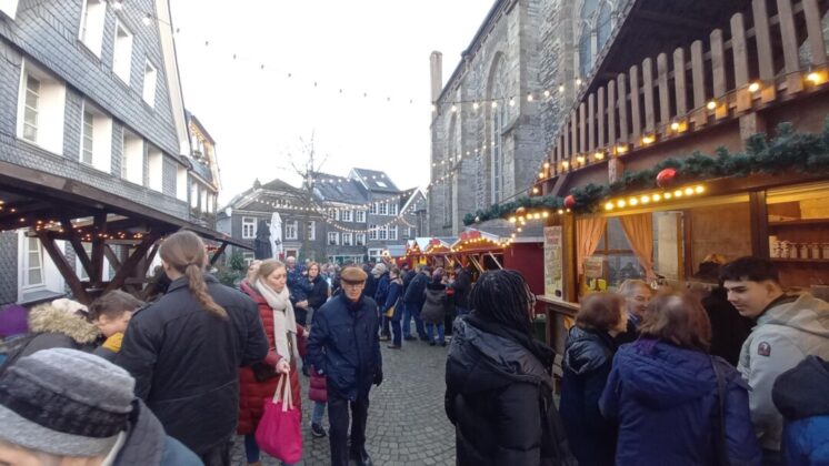 Weihnachtsmarkt mit Menschen und festlichen Buden in Deutschland.