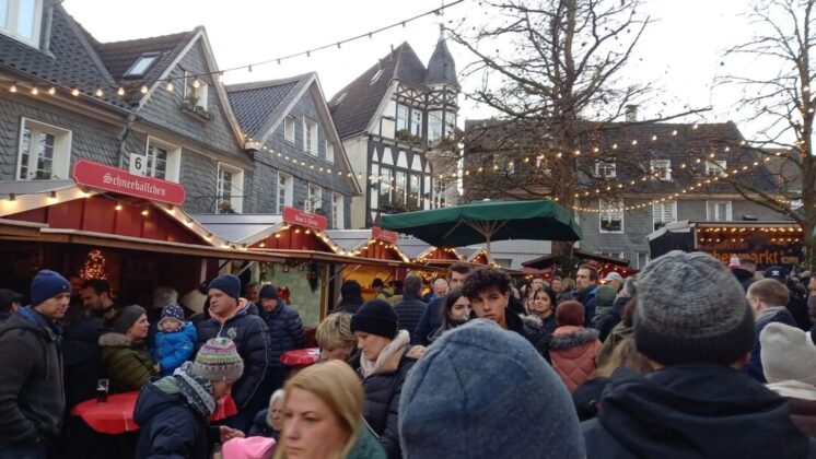 Weihnachtsmarkt mit Besuchern und Fachwerkhäusern.