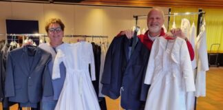 Für Kommunion und Karneval: Kleider-Tauschbörse in Heiligenhaus Zwei Personen präsentieren Kleidung für besondere Anlässe.