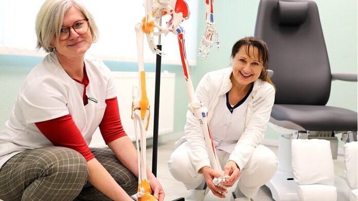 Podologie Neviges Physiotherapeuten mit Skelettmodell im Behandlungsraum.