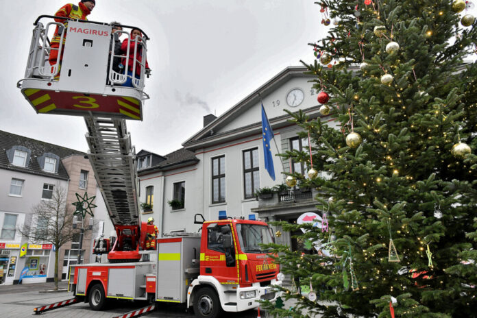 Feuerwehr dekoriert Weihnachtsbaum mit Drehleiter.