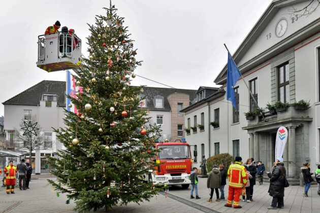 Feuerwehr dekoriert Weihnachtsbaum mit Drehleiter.