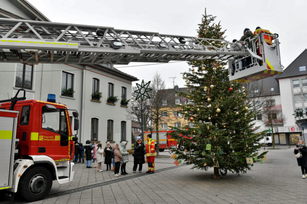 Feuerwehr dekoriert Weihnachtsbaum mit Drehleiter.