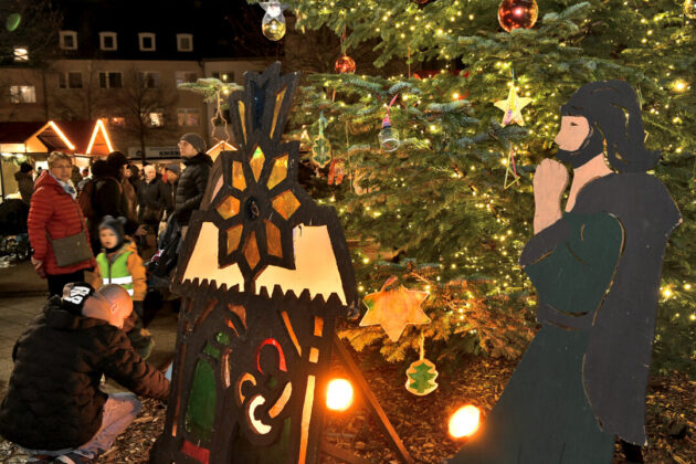 Weihnachtsmarkt, beleuchteter Baum, Holzfiguren.