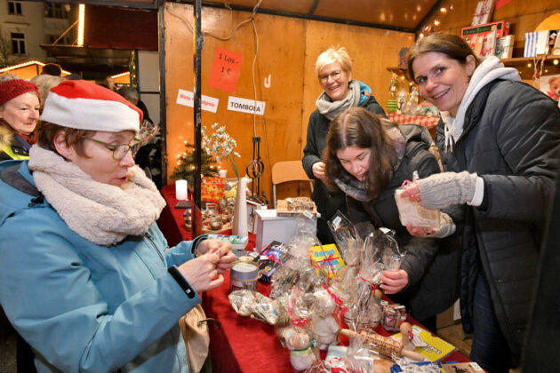Menschen auf Weihnachtsmarkt am Losstand.