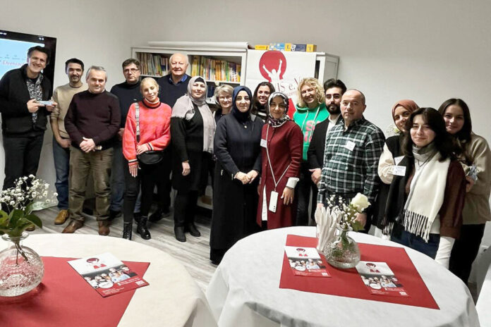 Gruppenfoto bei einer Veranstaltung mit Banner im Hintergrund.
