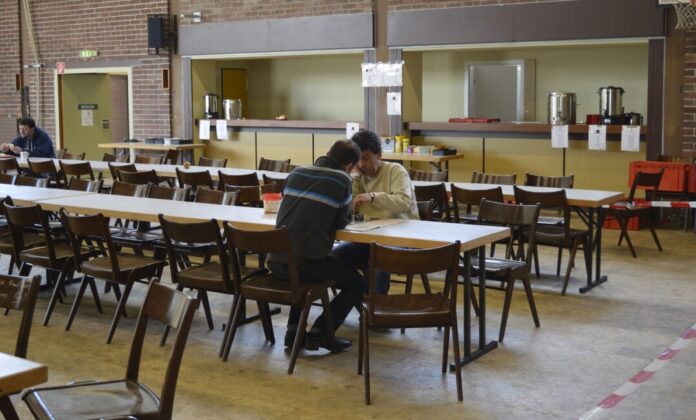 Menschen spielen Schach in Gemeinschaftshalle.