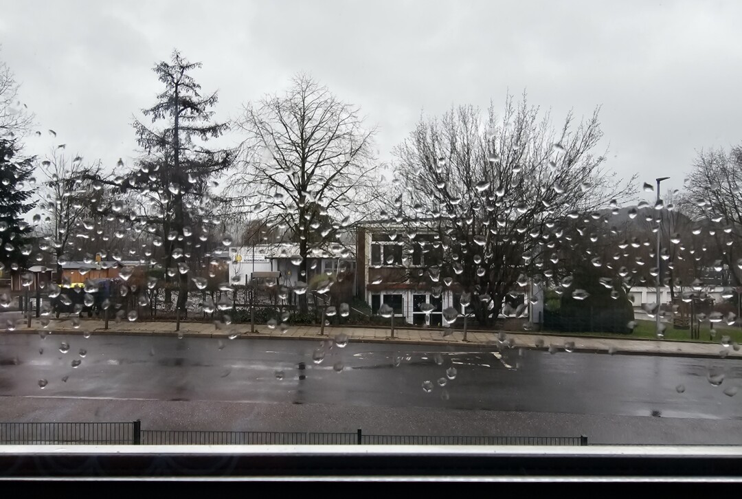 Verregneter Stadtblick durch Fenster.