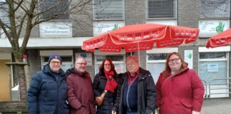 Fünf Personen vor Geschäft mit SPD-Sonnenschirmen.