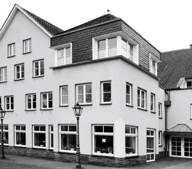 Weißes Eckhaus in deutscher Kleinstadt.