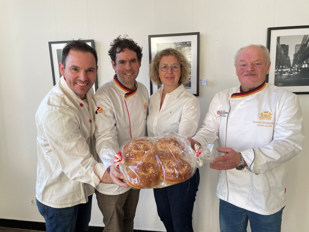 Matthias Bär (l.), Johannes Dackweiler (2. v. l.) und Johann Johannisbauer überreichen Bürgermeisterin Sandra Pietschmann den süßen Neujahrsgruß. Foto: Kreisstadt Mettmann