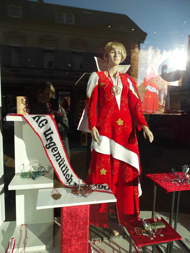 Schaufensterpuppe in traditioneller roter Kleidung.