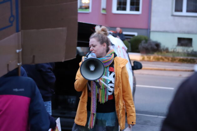 Frau spricht in Megafon bei Demonstration