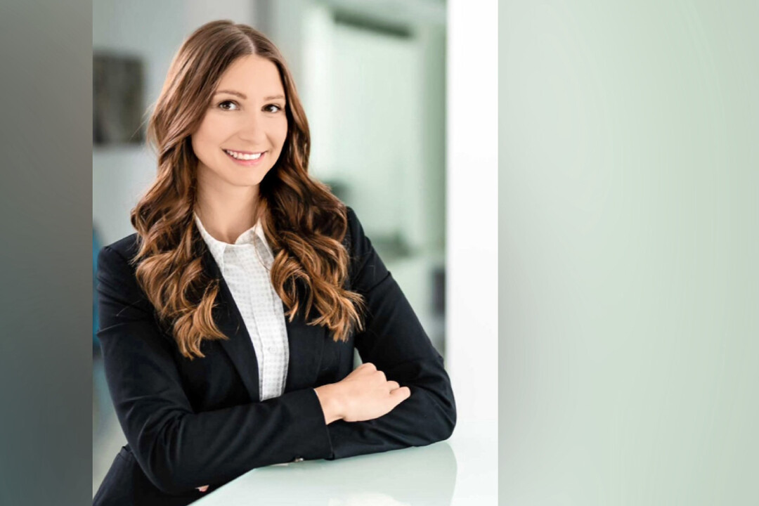 Frau in Business-Kleidung lächelt freundlich.