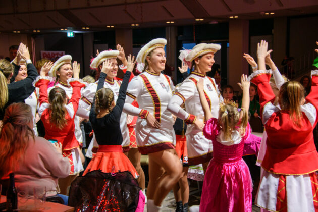 Karnevalstänzerinnen in traditionellen Kostümen beim Feiern.