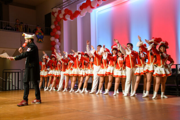 Karneval Tanzgruppe auf Bühne mit Dekoration.