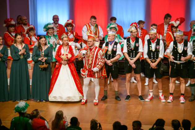 Karnevalssitzung mit Prinzenpaar und Narren in Trachten.