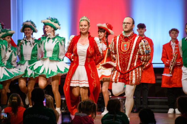 Karnevalstänzer auf Bühne in traditionellen Kostümen.