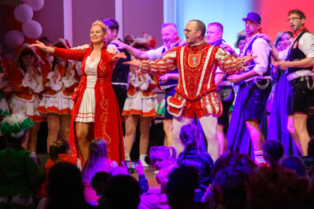 Karnevalstänzer in traditionellen Kostümen auf der Bühne.