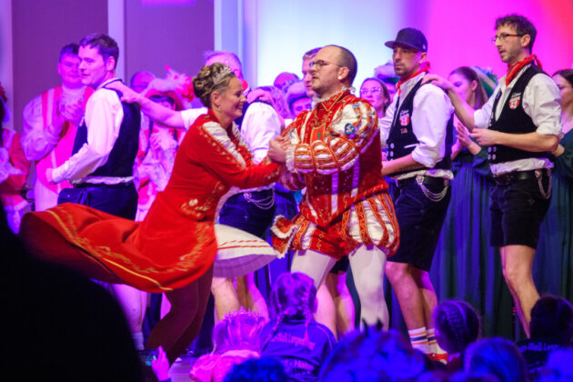 Leute tanzen in traditioneller deutscher Tracht.