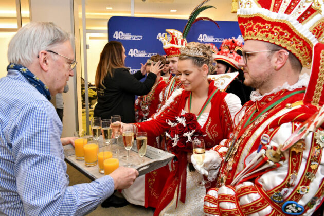 Karnevalsfeier mit Kostümen und Sekt.