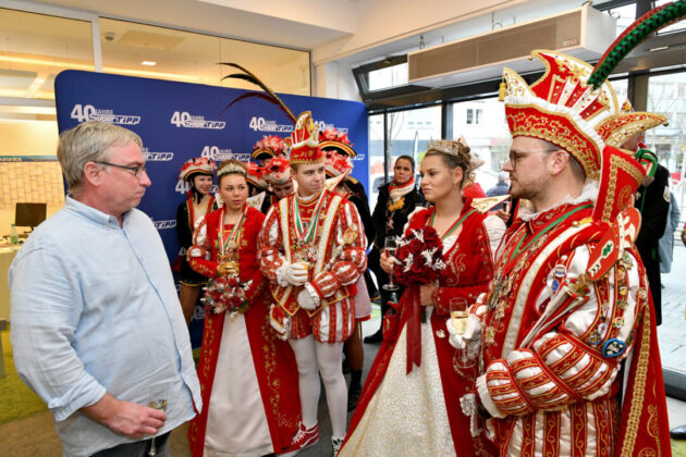 Personen in traditioneller Karnevals-Kleidung bei Veranstaltung.