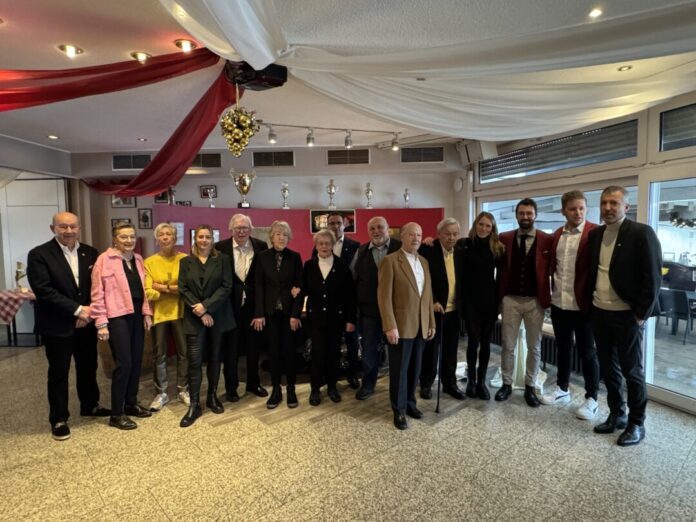 Gruppenfoto in einem Veranstaltungsraum mit Trophäen.