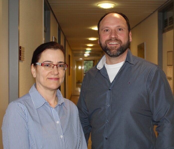 Zwei Personen stehen im Büroflur.