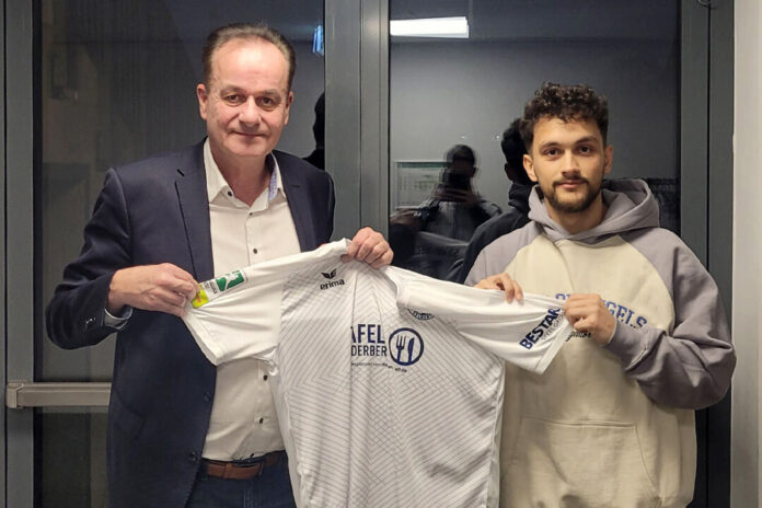 Zwei Personen halten ein Fußballtrikot.