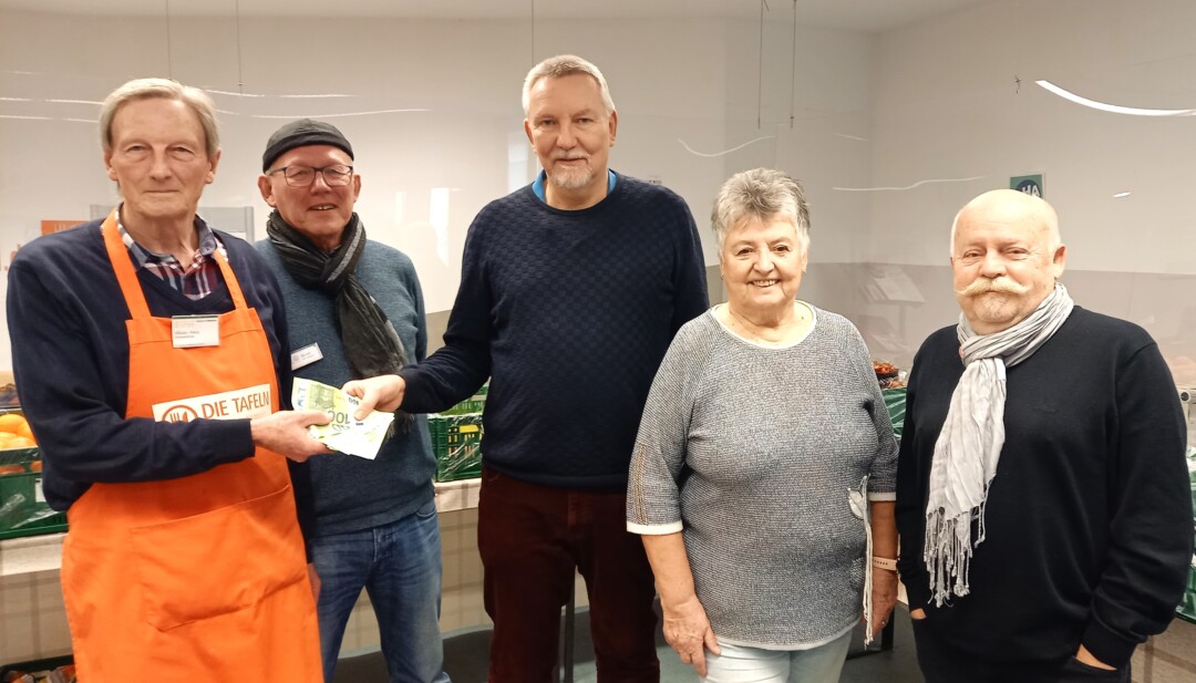 Gruppe bei Spendenübergabe in Lebensmittelausgabe.