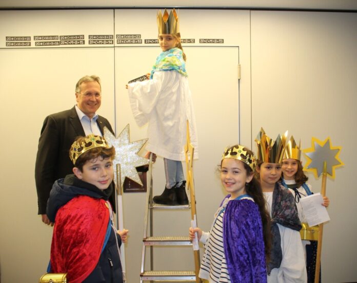 Kinder in Kostümen spielen Könige und Sternträger.
