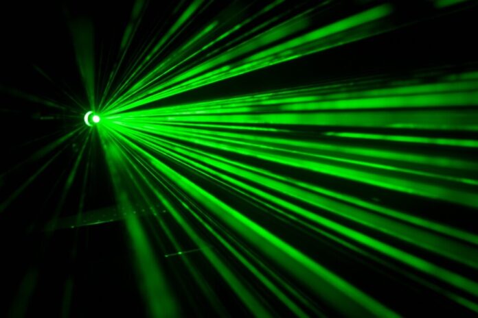 Grüne Laserstrahlen im Dunkeln.
