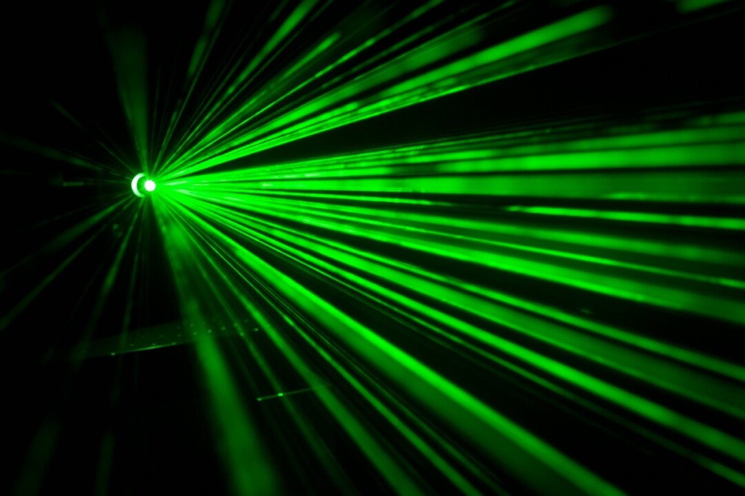 Grüne Laserstrahlen im Dunkeln.
