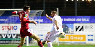 Fußballspiel bei Nacht, Zweikampf um den Ball.